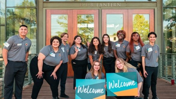 city year americorps member sitting next to a student as he does his work at a desk